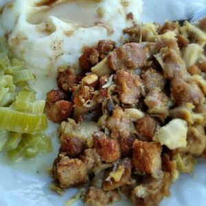 chicken roasht on a plate with mashed potatoes and cooked celery.