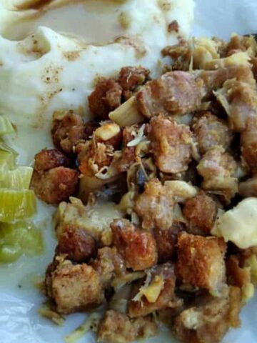 chicken roasht on a plate with mashed potatoes and cooked celery.