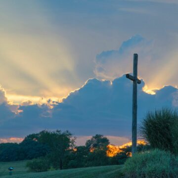 a beautiful sunrise and a cross standing tall as a sign of what Jesus has done for us on Easter holiday.