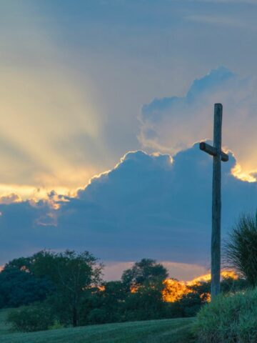 a beautiful sunrise and a cross standing tall as a sign of what Jesus has done for us on Easter holiday.