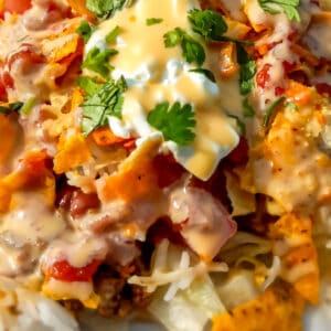 a delicious-looking Amish haystack dinner on a plate topped with cheese sauce.