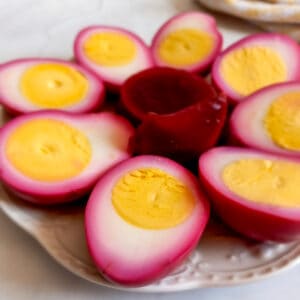 a small plate filled with halved PA Dutch red beet eggs and a few beet slices.