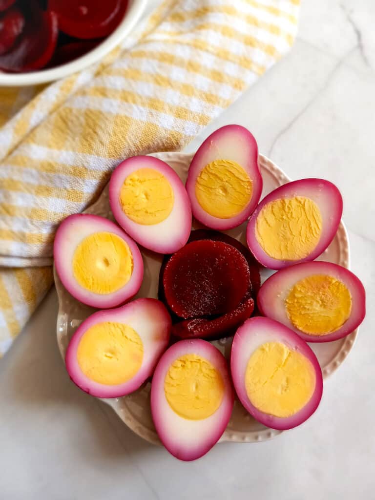 halved pickled red beet eggs on a plate.