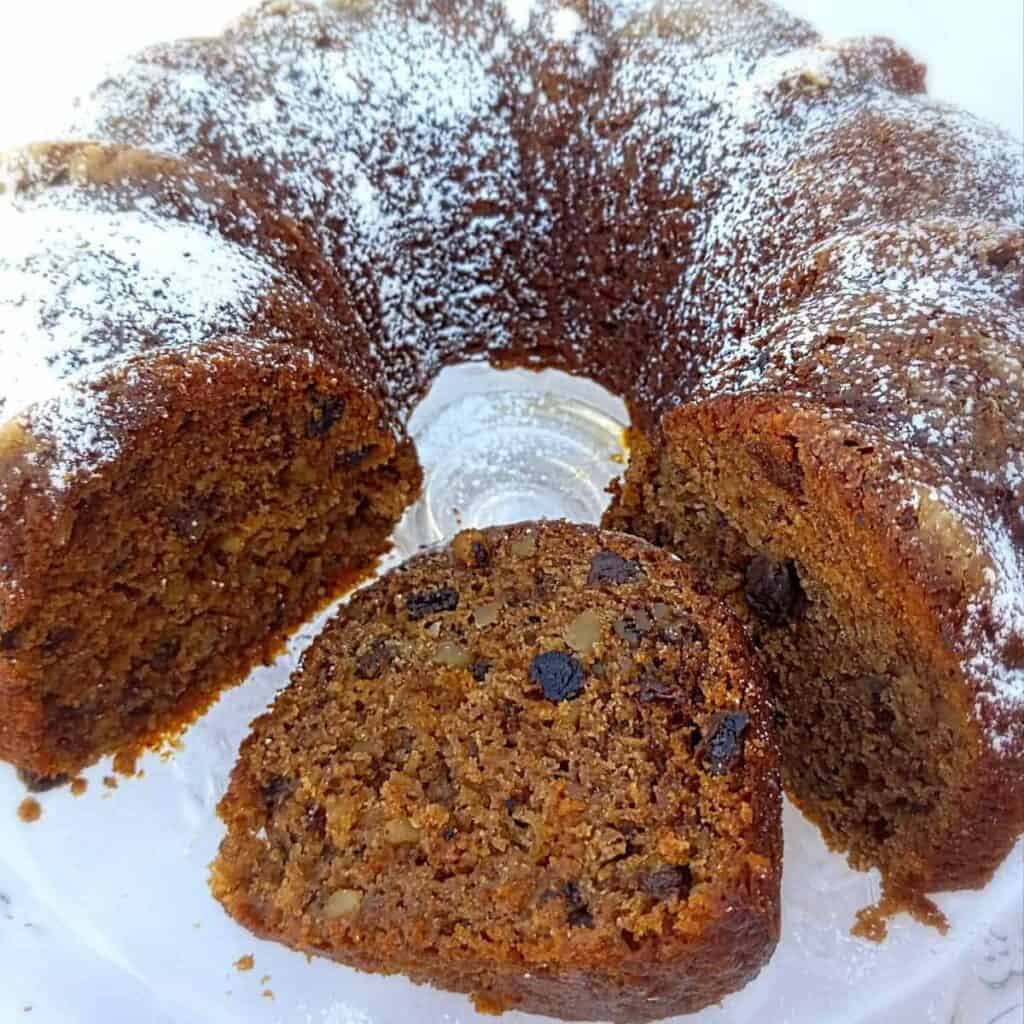 Amish applesauce cake baked in bundt pan and topped with powdered sugar.