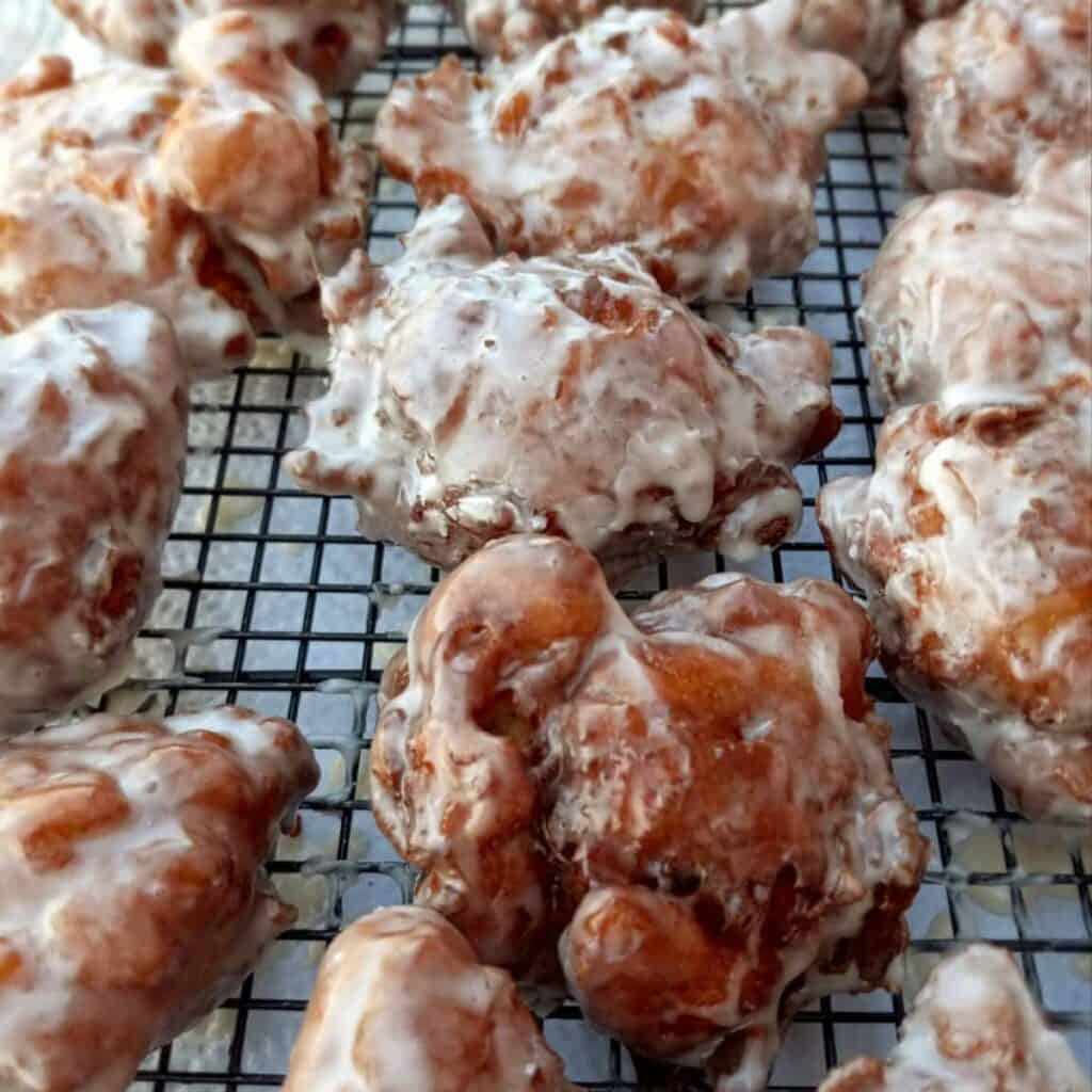 homemade apple fritters on a wire rack.