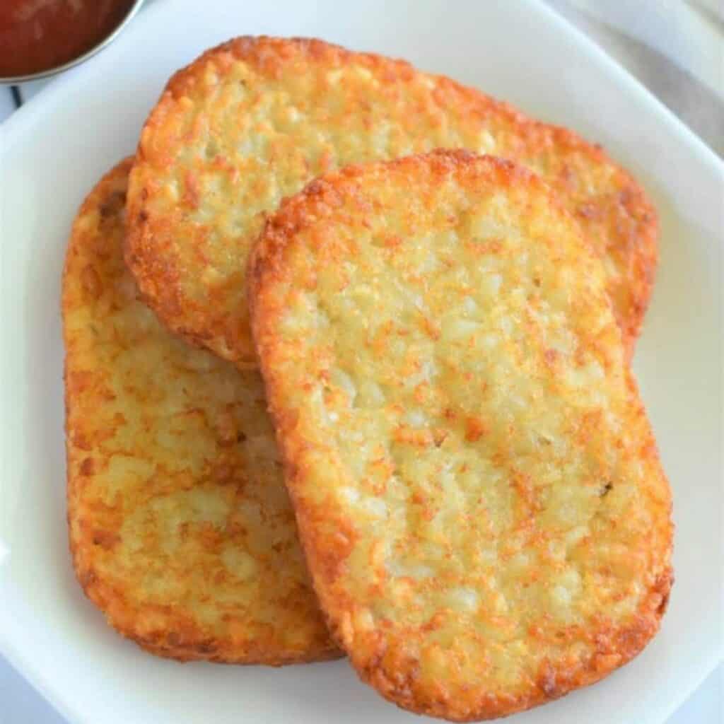 three hash brown patties on a plate.