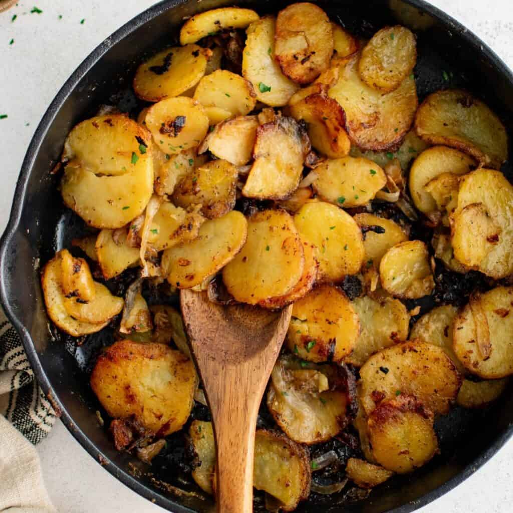a skillet full of fried potatoes and onions to serve with biscuits and gravy.