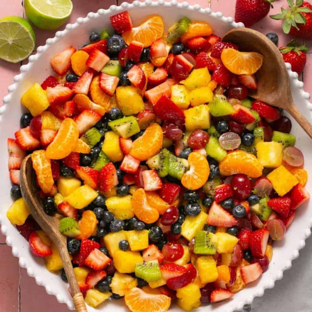 a large bowl of rainbow fruit salad with lime dressing.