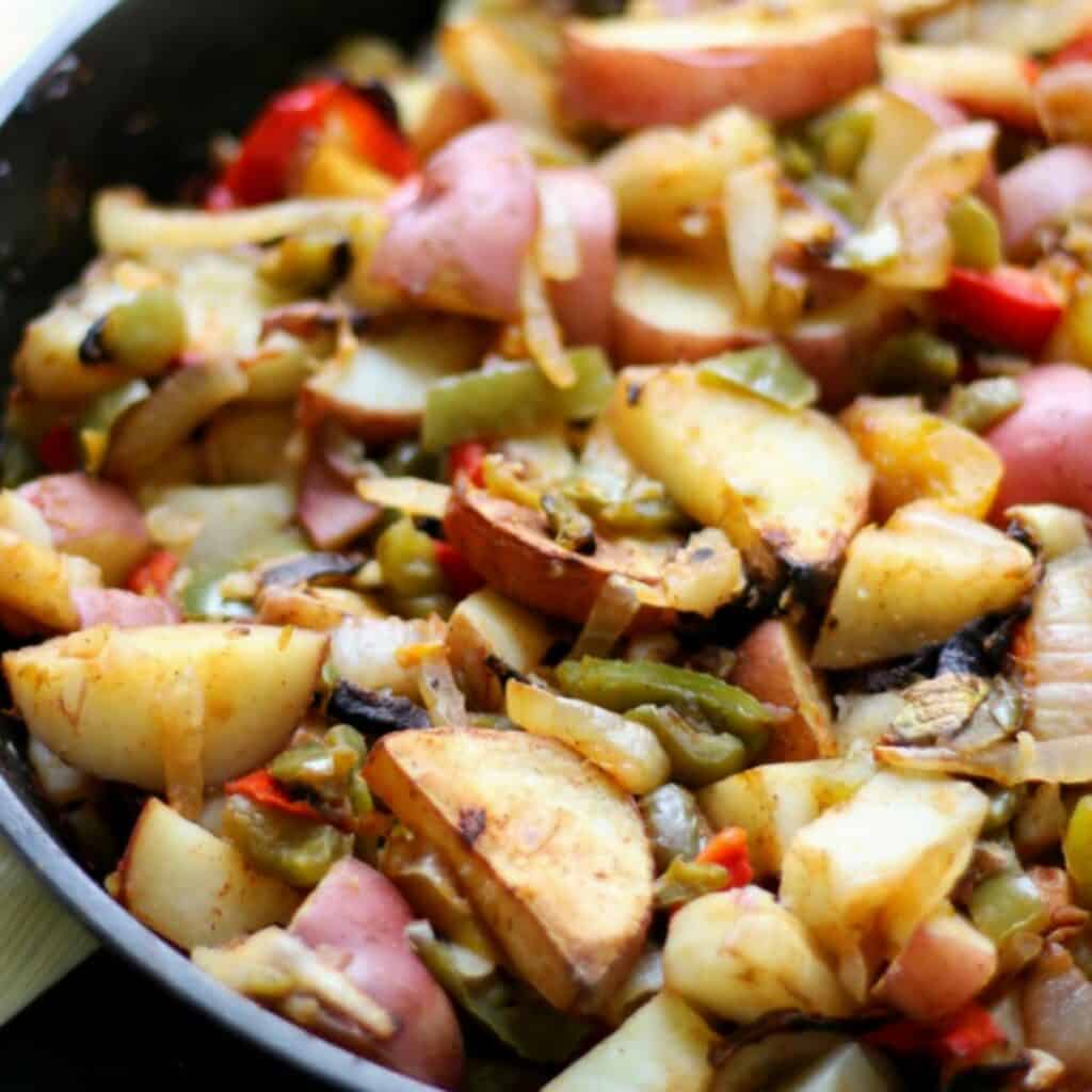 fried potatoes, onions, and peppers in skillet.