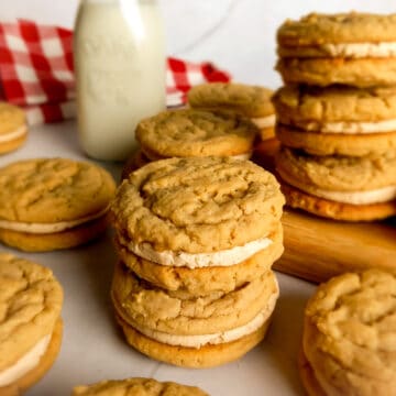 Amish peanut butter cookies with peanut butter filling stacked around a board.