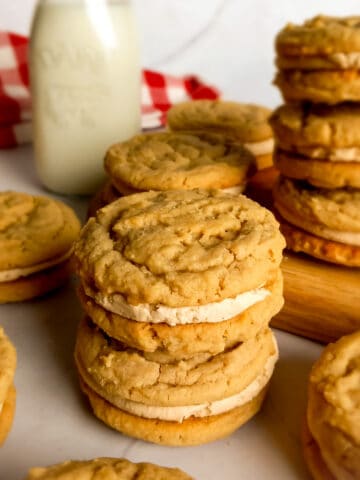 Amish peanut butter cookies with peanut butter filling stacked around a board.