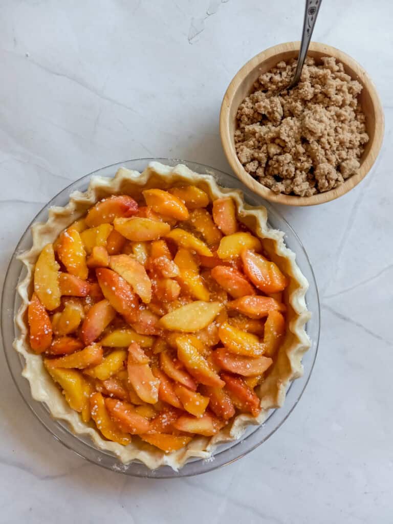 pie filling in the shell and crumble topping in a small bowl.