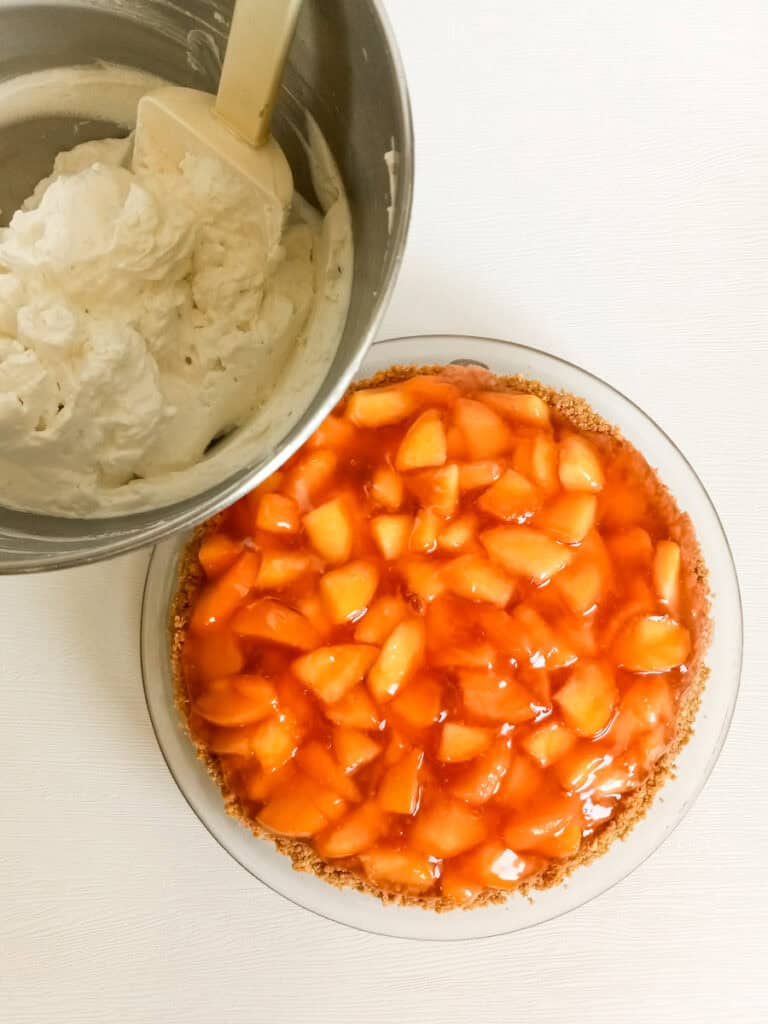 9" fresh peach pie and a bowl of whipped cream.