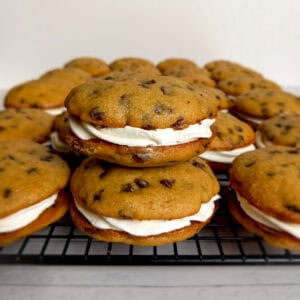 chocolate chip whoopies on a wire rack, two stacked in focus.