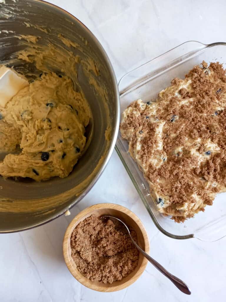 cake batter in a bowl, streusel in a tiny bowl and some cake batter and streusel layered in a pan.