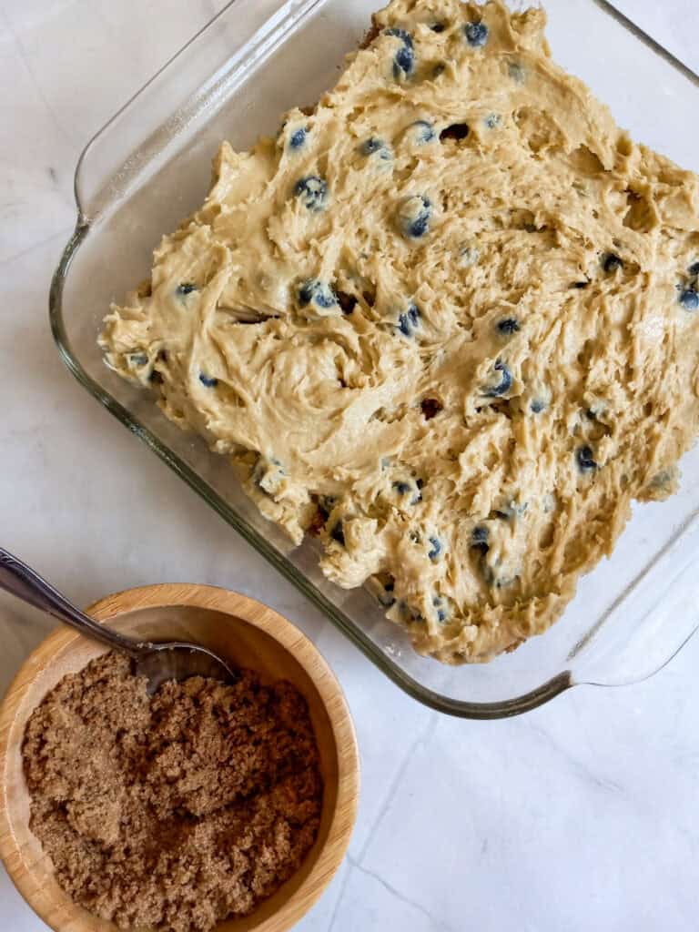 the batter spread into a pan, ready to spread the remaining streusel on top.