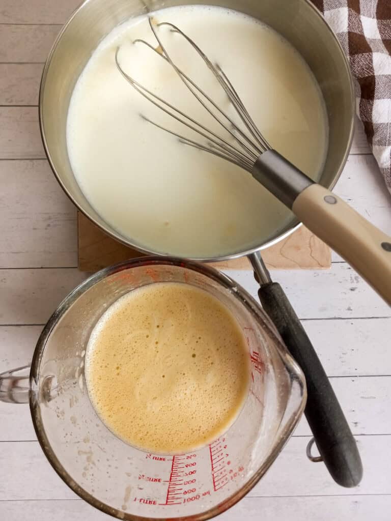 a pot of milk and a glass pitcher of beaten eggs mixture.