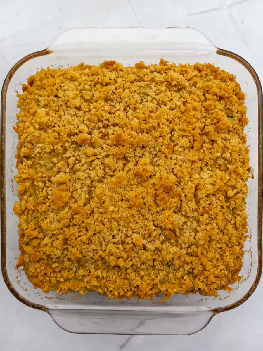 9" square dish of zucchini casserole topped with cracker crumbs.