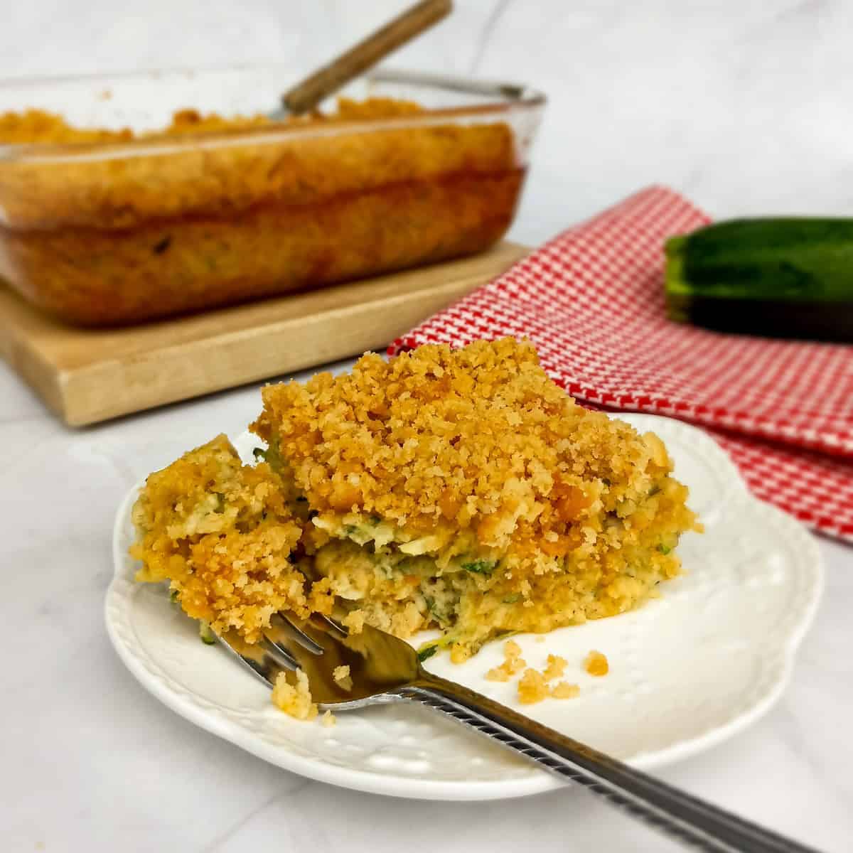 getting ready to enjoy a bite of Amish zucchini casserole from a serving on a plate.