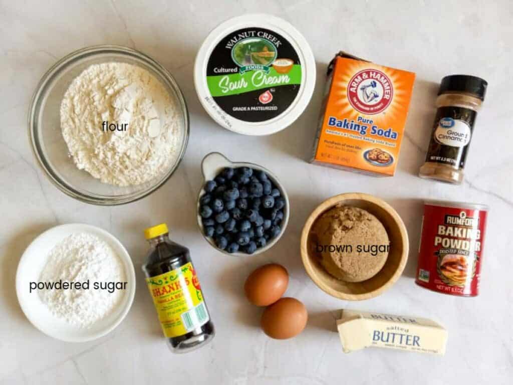Ingredients: flour, brown sugar, butter, blueberries, baking powder, baking soda, sour cream, eggs, vanilla, powdered sugar, and cinnamon.