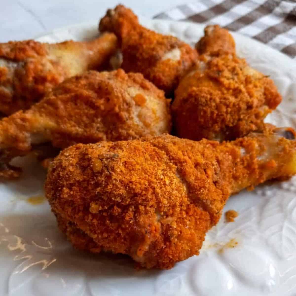 a plate full of shake and bake chicken legs.