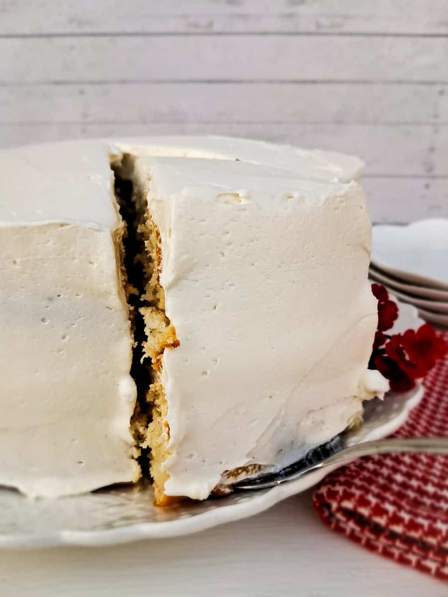 a layered white cake with a slice cut out.