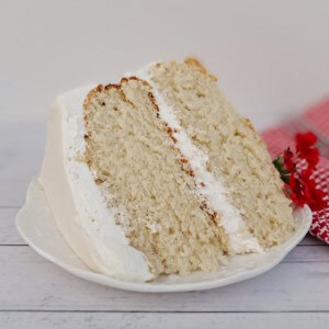 a large slice of frosted white cake on a plate.