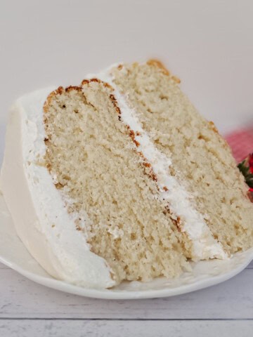 a large slice of frosted white cake on a plate.