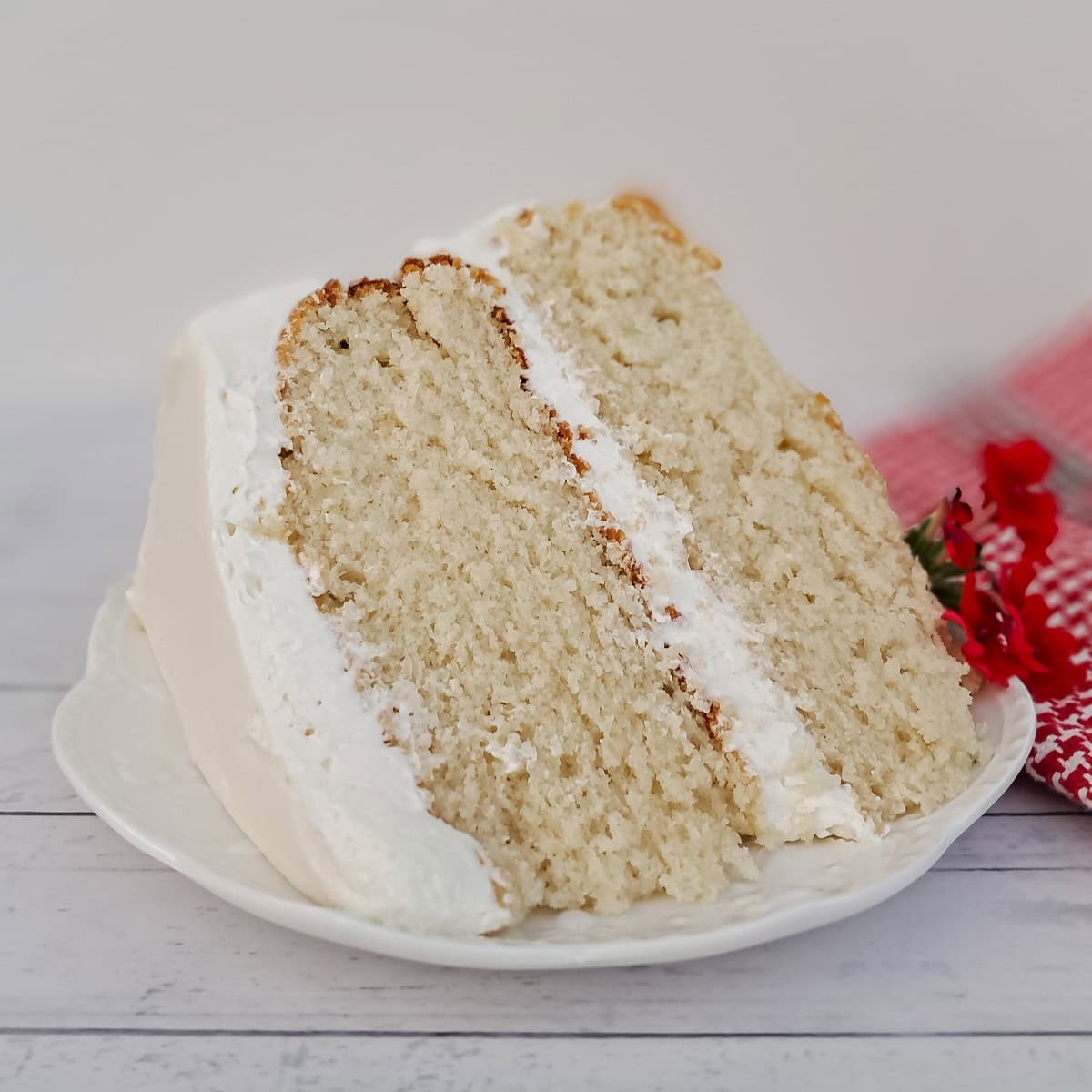a large slice of frosted white cake on a plate.