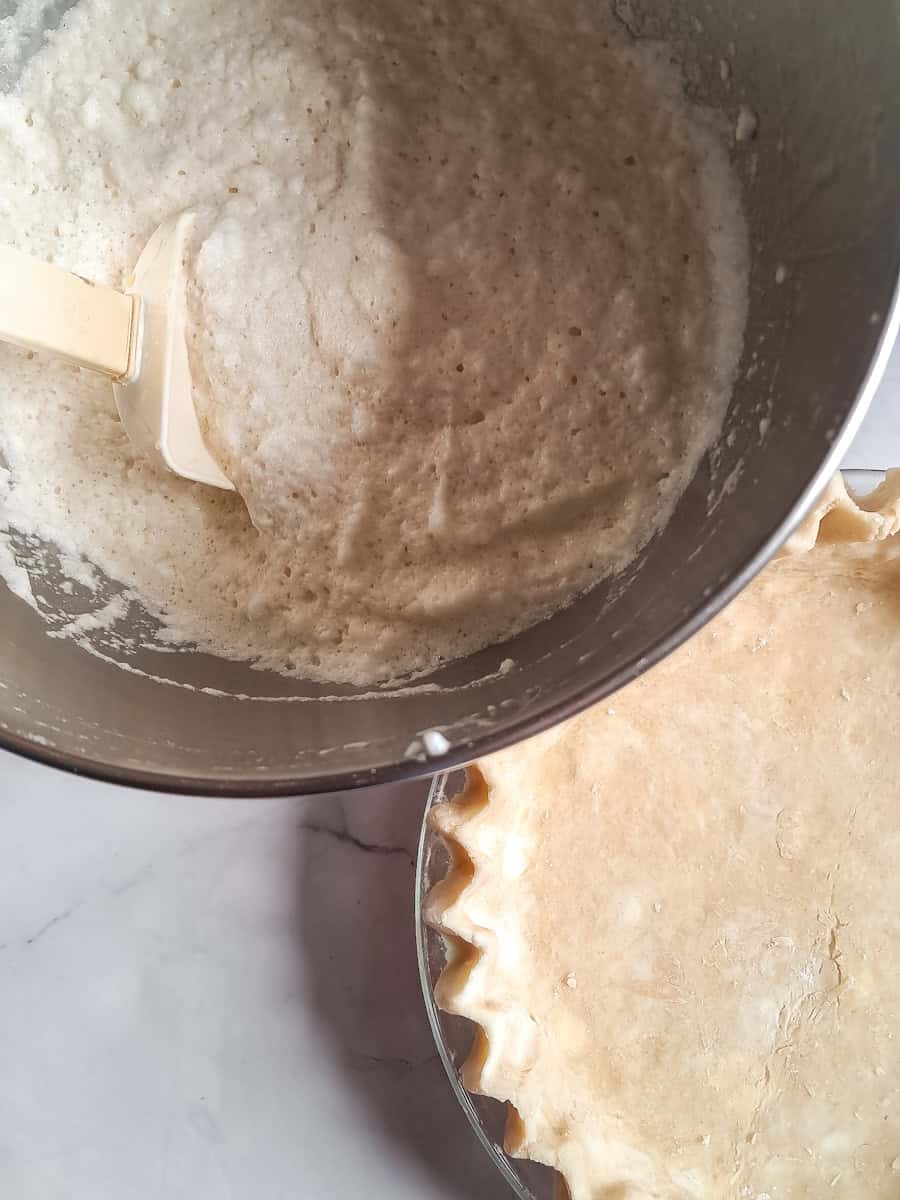 custard filling in a bowl and an empty pie shell.