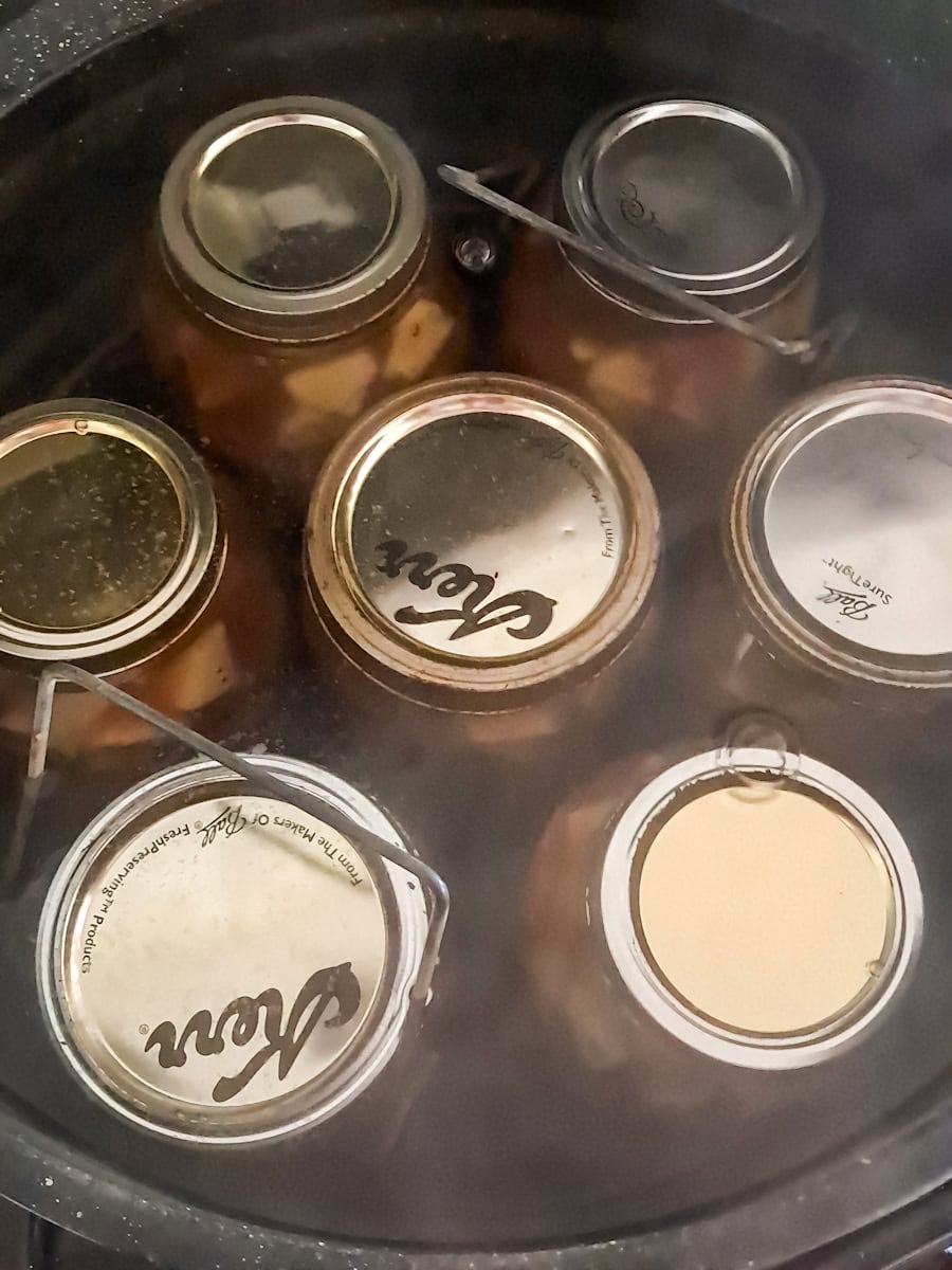 canning apple pie filling in a canner full of water.