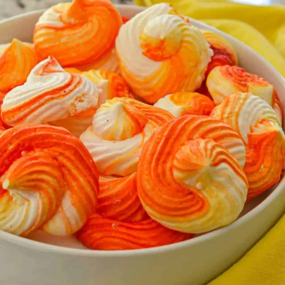 a bowl of orange swirl meringue cookies.