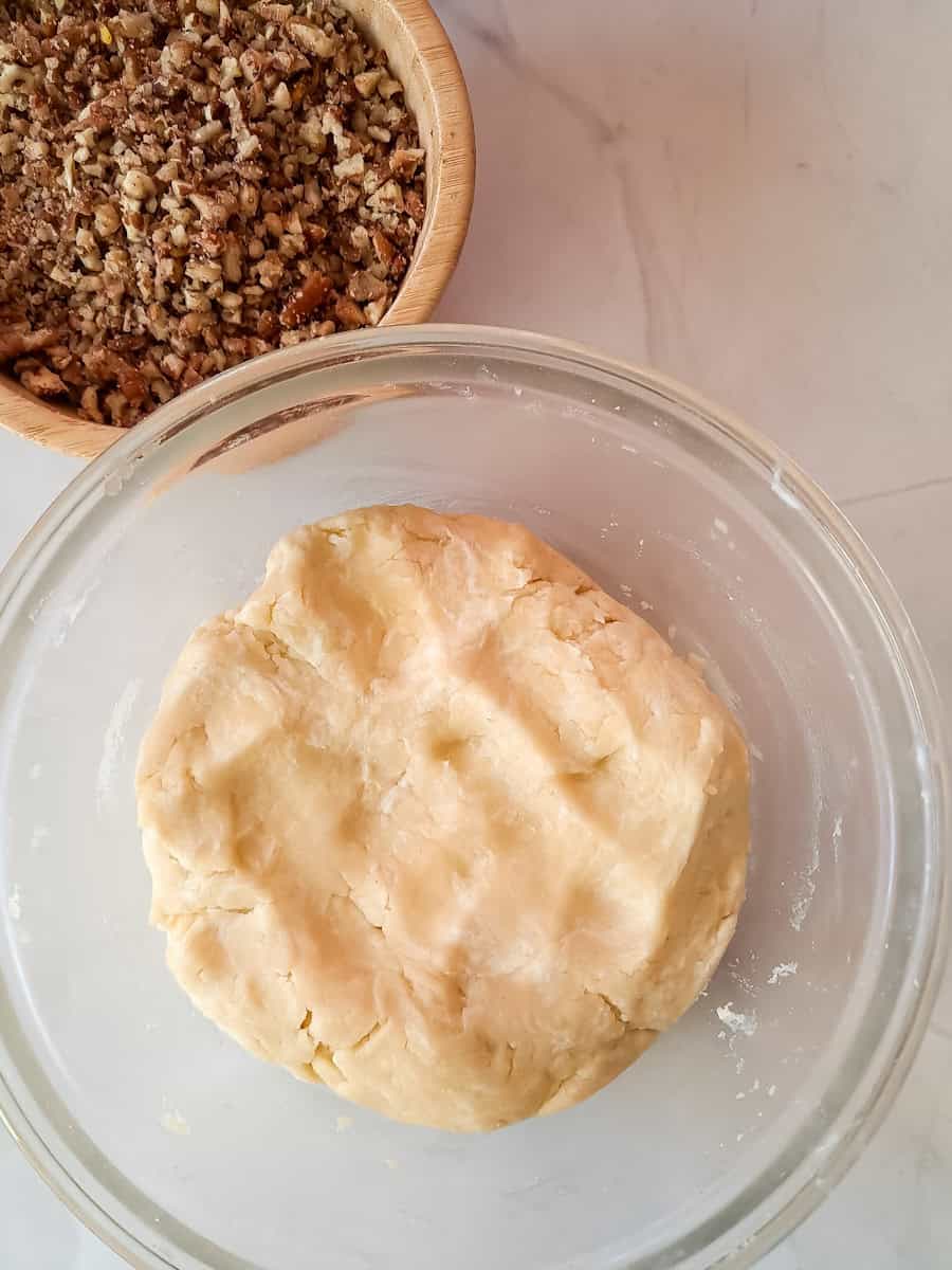 crust dough in one bowl, chopped pecans in another bowl.