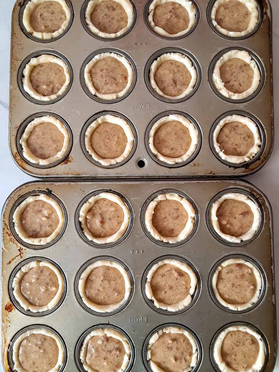 pecan tarts in muffin tins ready to bake.