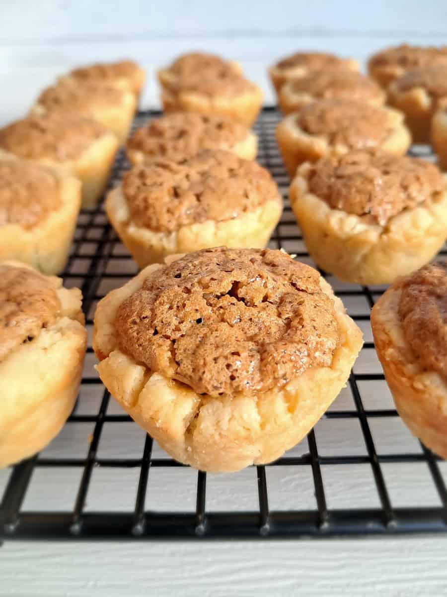 mini pecan pies on a wire cooling rack.