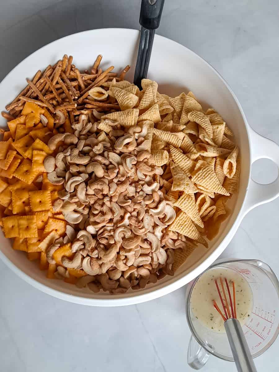 snack ingredients in bowl and a cup with oil and seasoning.