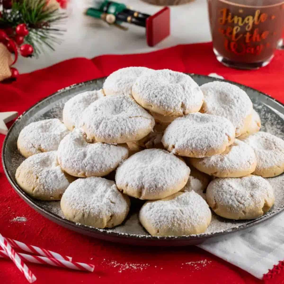 a plate full of kourabiedes cookies.
