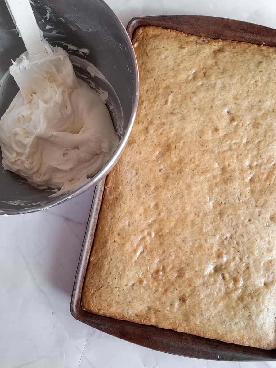 baked pan of banana bars and a bowl of cream cheese frosting.