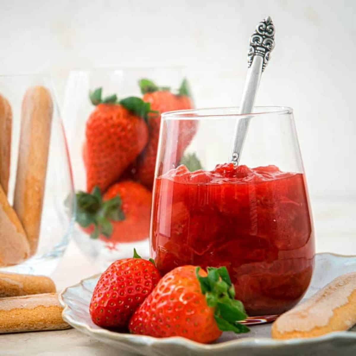 A glass cup of strawberry rhubarb sauce.