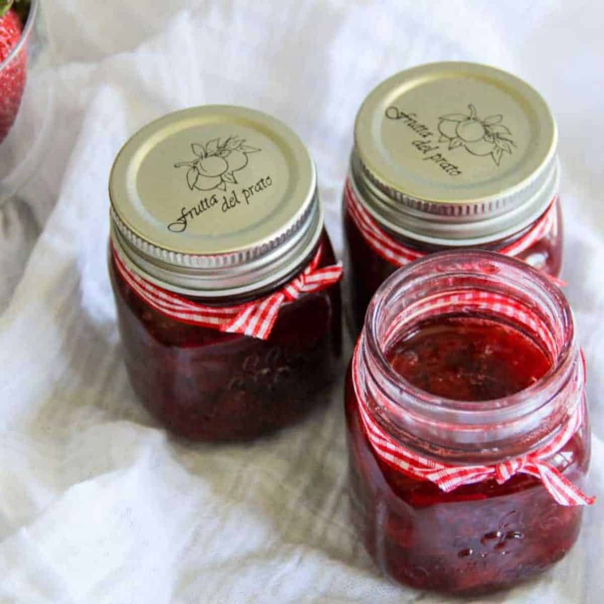small jars full of strawberry syrup.