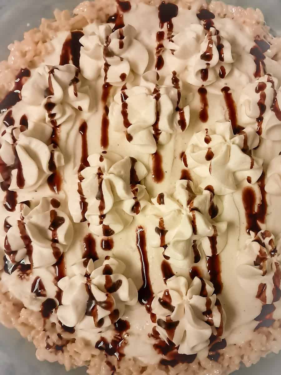 Rice Krispie ice cream pie topped with whipped cream and chocolate drizzle.