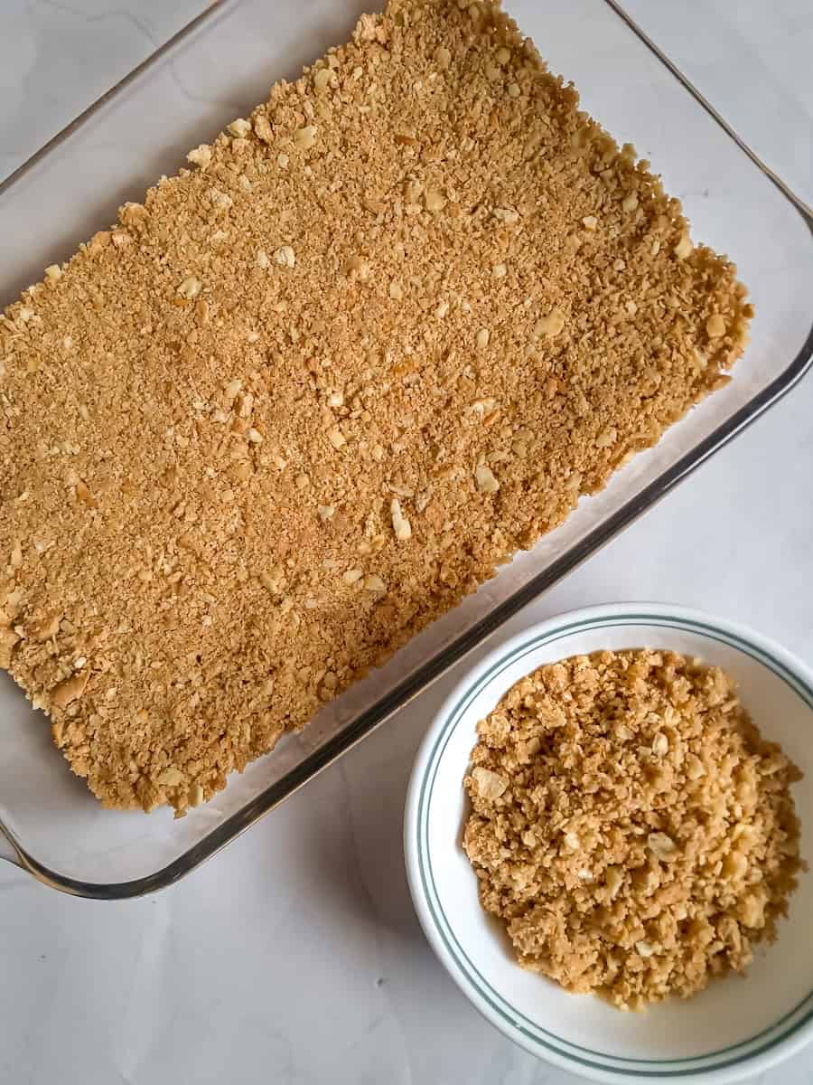 graham crust in 9x13" panand reserved crumbs in bowl.