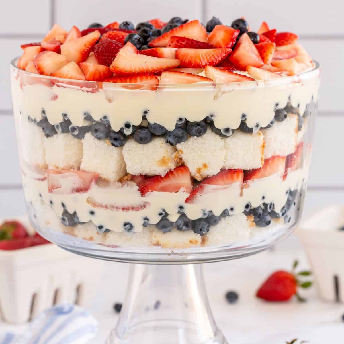 trifle bowl full of layered angel food cake, berries, and pudding.