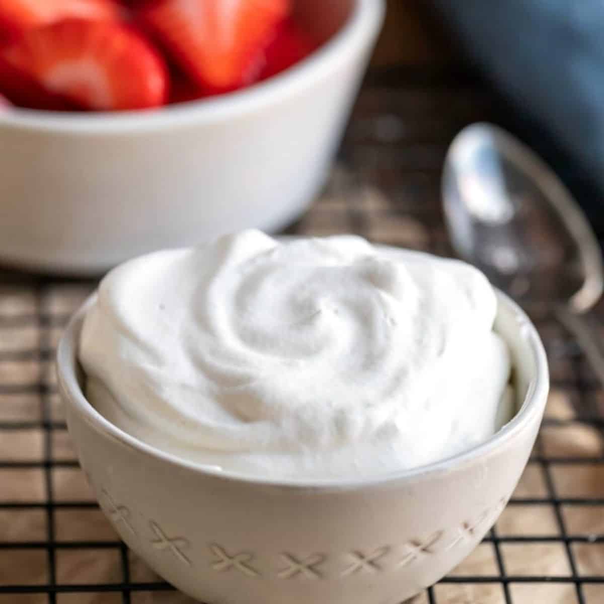 small dish of homemade whipped cream and a bowl of strawberries.
