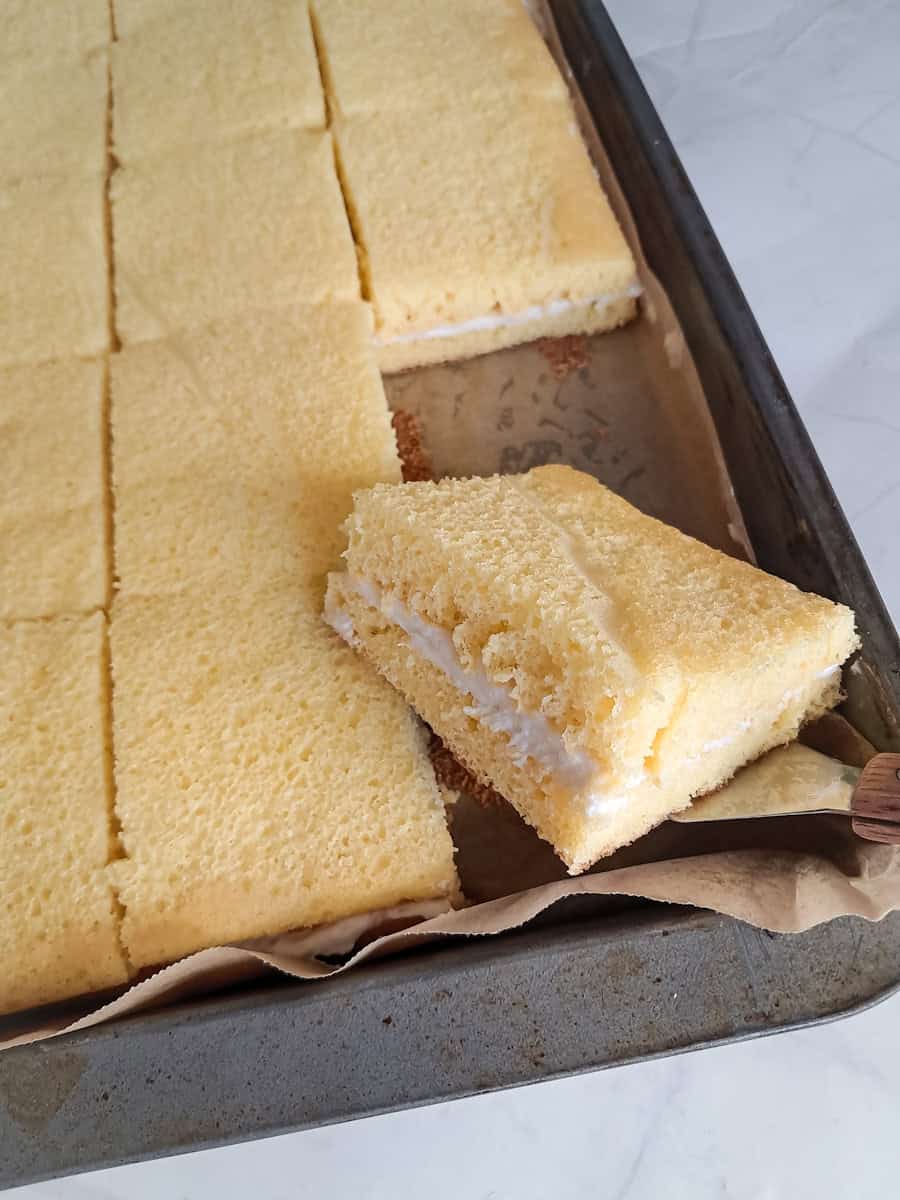 a sheet pan full of twinkies cake cut into squares - let's show you one slice.