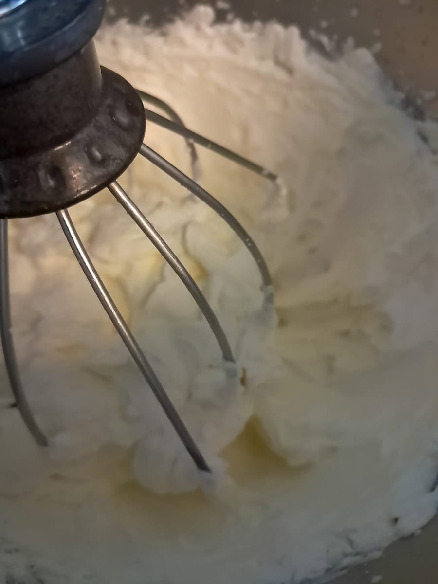 whipped cream in bowl with whisk.