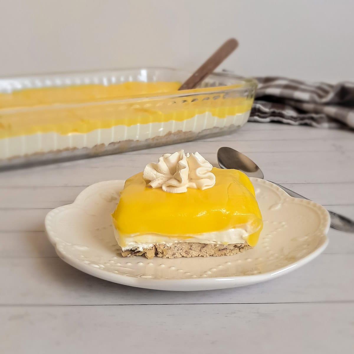 a 9x13" pan of Amish lemon dessert and a slice on a small plate.
