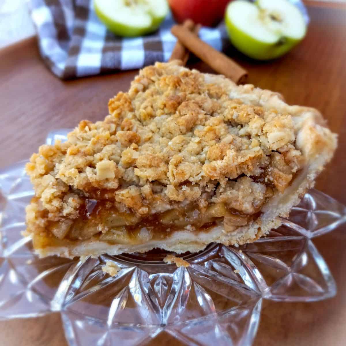 a slice of dutch apple pie with crumb topping.