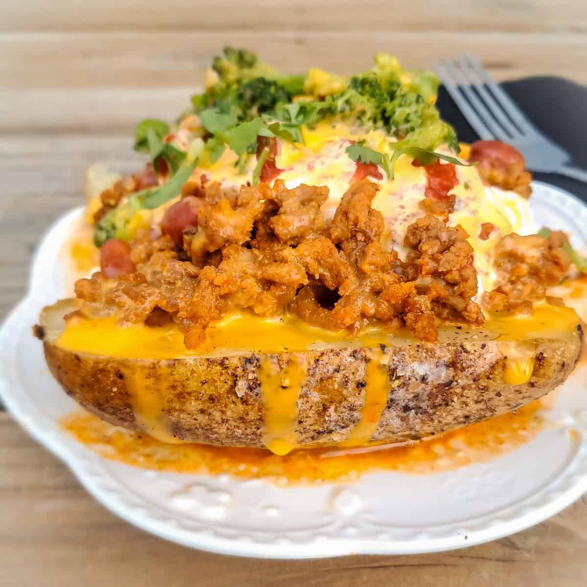 delicious looking baked potato piled with toppings.