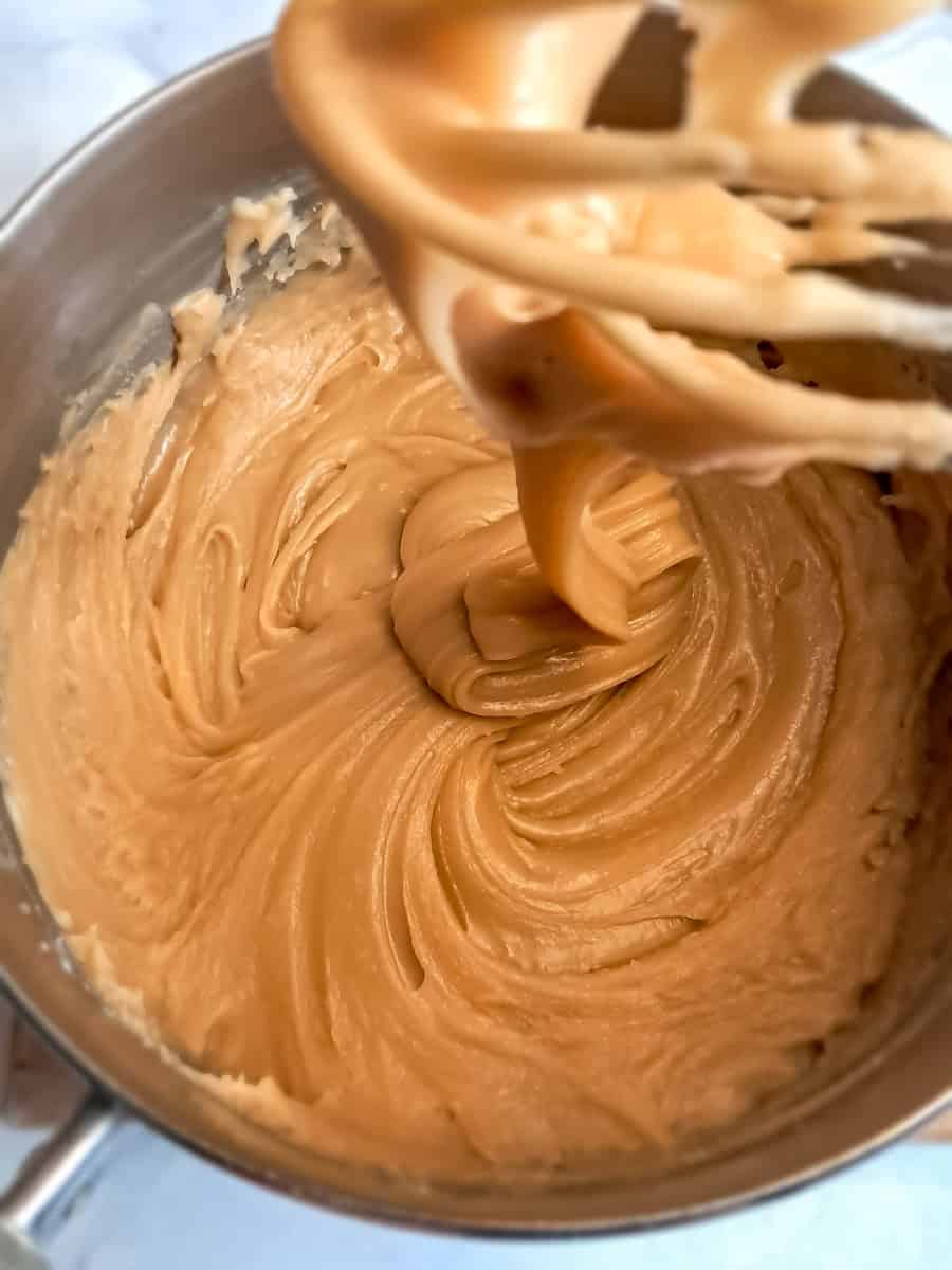 drizzling caramel frosting off of a wire whisk.